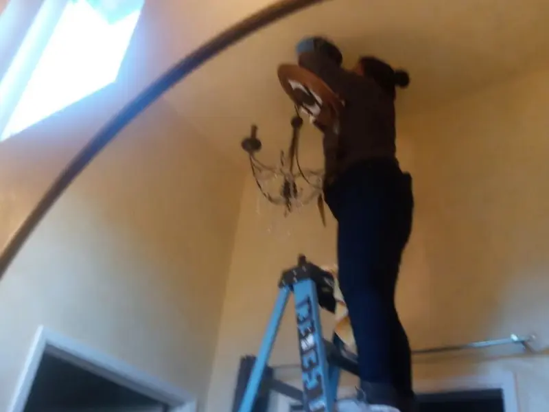 Electrician installing a chandelier in a Kettering residence
